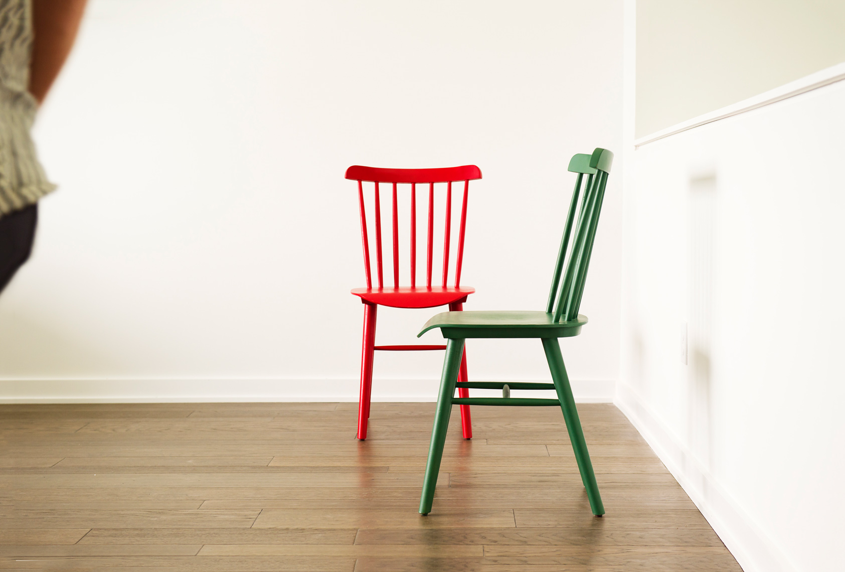 one red and one green wood dining chairs in interior